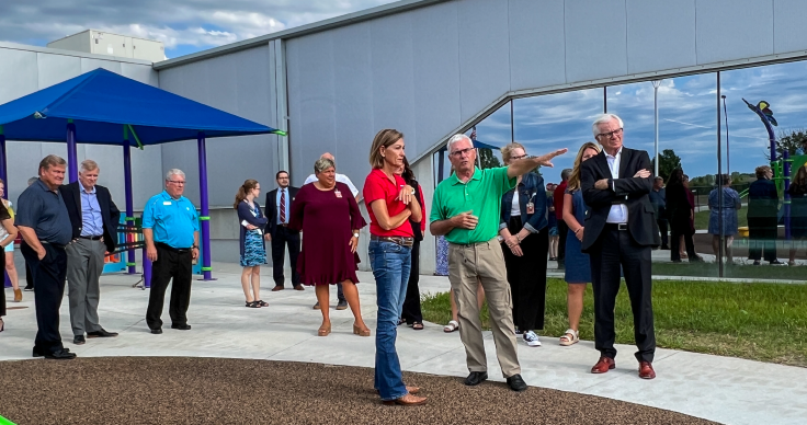 A crowd stands around a newly opened child care center