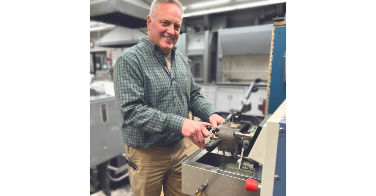 A man works at a machine in a manufacturing plant