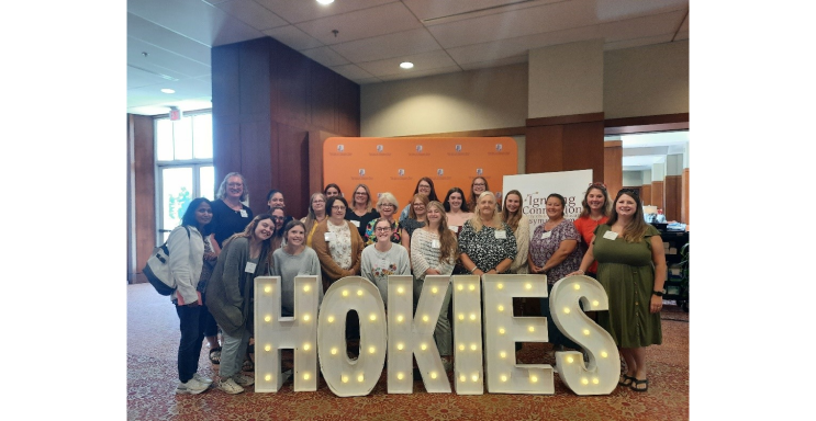 group picture in front a sign for the Hokies